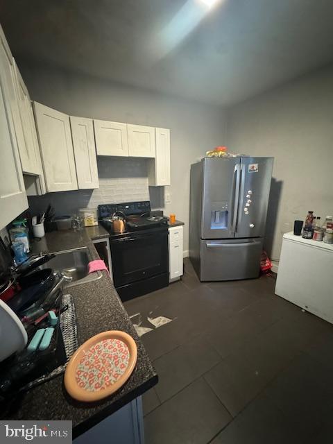 1341 E Rittenhouse St, Philadelphia, PA 19138 - kitchen featuring dark countertops, tasteful backsplash, black electric range, stainless steel fridge with ice dispenser, and white cabinets