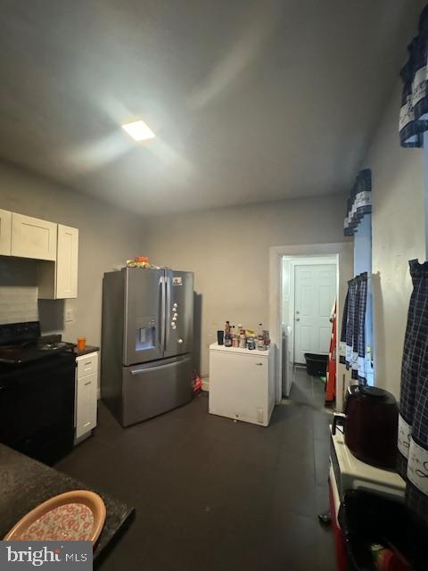 1341 E Rittenhouse St, Philadelphia, PA 19138 - kitchen featuring dark countertops, white cabinetry, gas stove, and stainless steel fridge