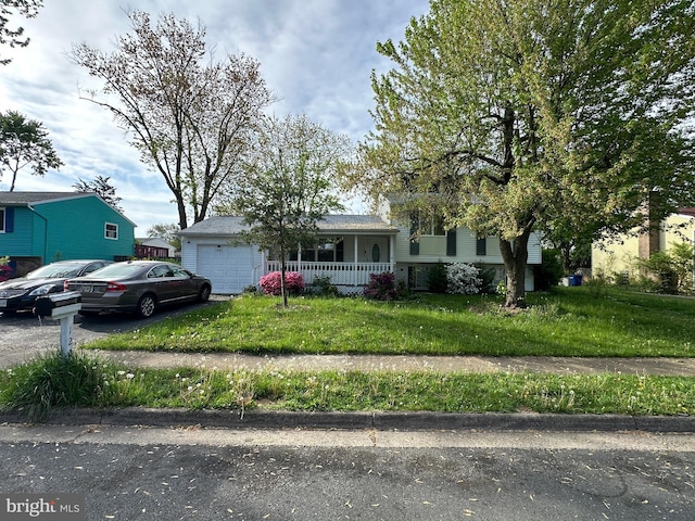 1207 Sunrise Ct, Herndon, VA 20170 - tri-level home with a porch, a front lawn, an attached garage, and asphalt driveway