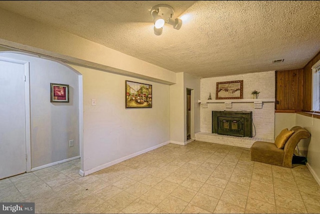 1207 Sunrise Ct, Herndon, VA 20170 - unfurnished living room with a fireplace, a textured ceiling, arched walkways, baseboards, and light flooring