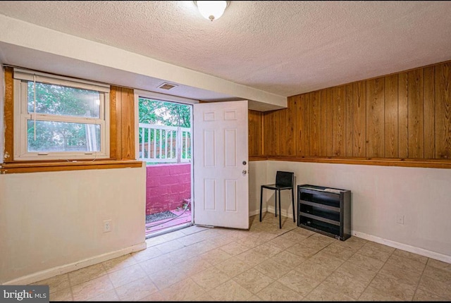 1207 Sunrise Ct, Herndon, VA 20170 - spare room featuring wooden walls, a textured ceiling, light floors, and baseboards