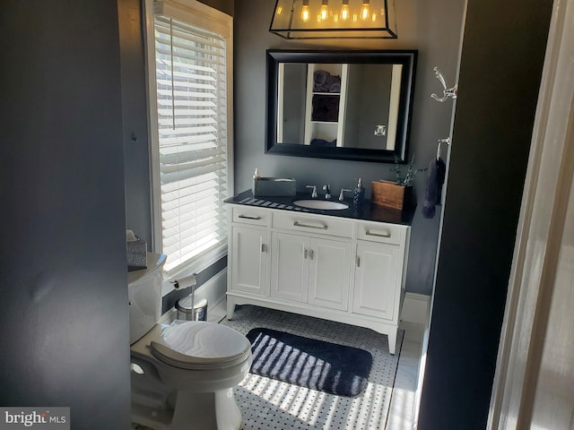 bathroom with a healthy amount of sunlight, toilet, and vanity
