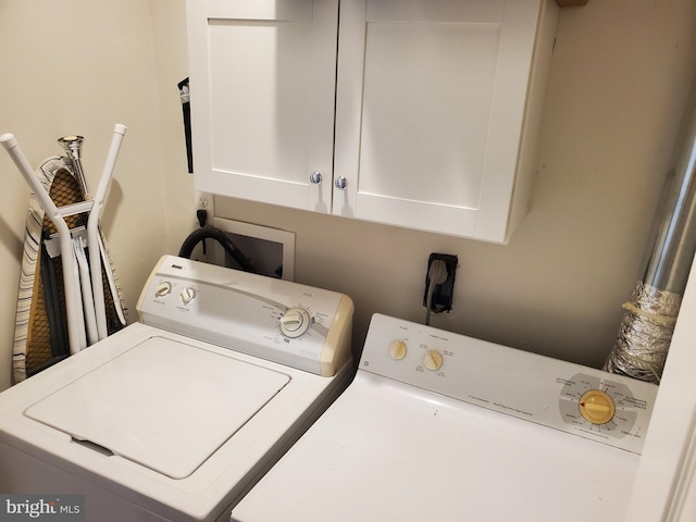 laundry room featuring separate washer and dryer and cabinet space