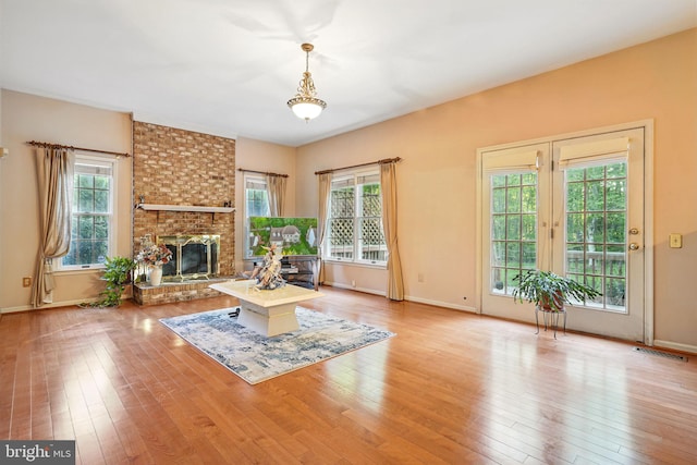 1728 Catherine Fran Dr, Accokeek, MD 20607 - unfurnished living room featuring a fireplace, baseboards, wood finished floors, and a healthy amount of sunlight
