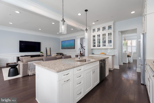 kitchen featuring a sink, appliances with stainless steel finishes, dark wood finished floors, and an island with sink