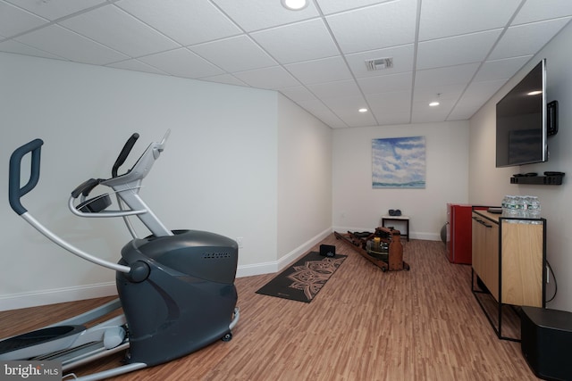exercise room featuring visible vents, wood finished floors, baseboards, a drop ceiling, and recessed lighting