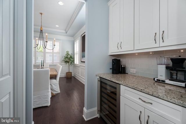 bar with an inviting chandelier, crown molding, tasteful backsplash, dark wood finished floors, and wine cooler