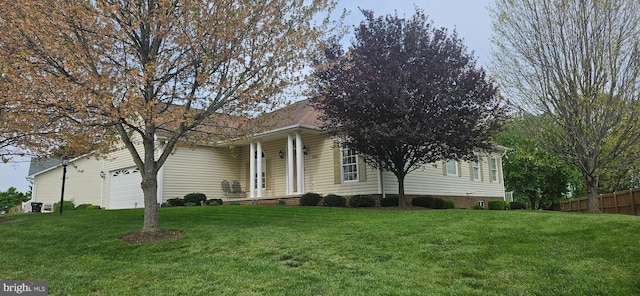 view of front of property featuring fence, an attached garage, and a front lawn