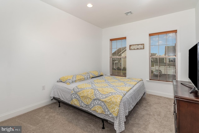 carpeted bedroom featuring recessed lighting, visible vents, and baseboards