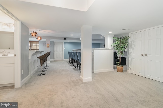 carpeted foyer with baseboards, a sink, visible vents, and recessed lighting