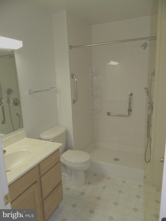 full bath featuring toilet, vanity, and a stall shower