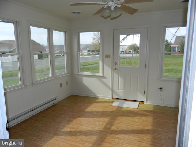 unfurnished sunroom with visible vents, a wealth of natural light, and a baseboard radiator