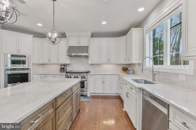 kitchen with a sink, stainless steel appliances, white cabinetry, under cabinet range hood, and recessed lighting