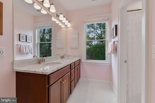 full bathroom featuring double vanity, plenty of natural light, and a sink