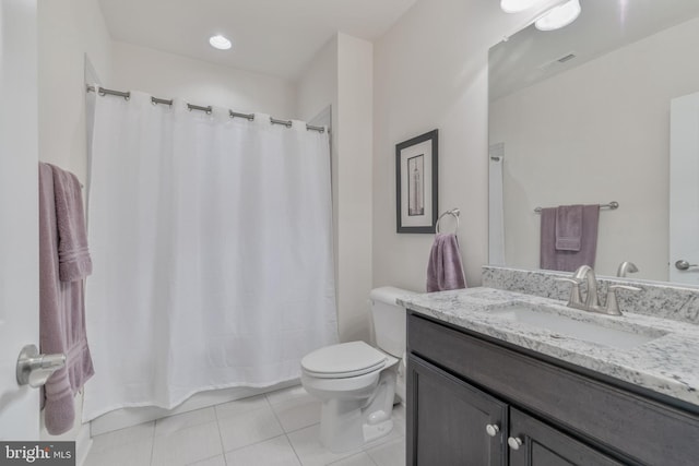 full bath with toilet, vanity, and tile patterned floors