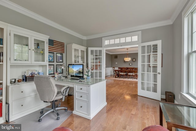 office featuring light wood-type flooring, ornamental molding, and french doors