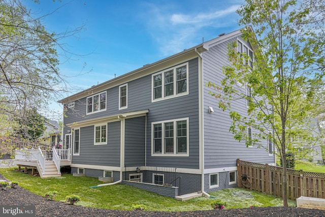 back of house with a yard, fence, and a deck