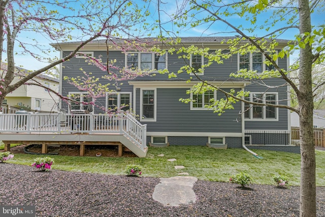 back of house featuring a lawn and a deck