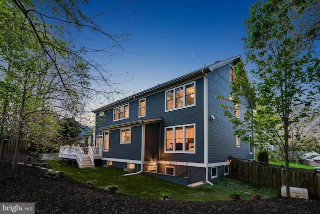 back of house with a lawn, fence, and a deck
