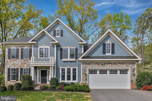craftsman inspired home featuring aphalt driveway, stone siding, and a standing seam roof