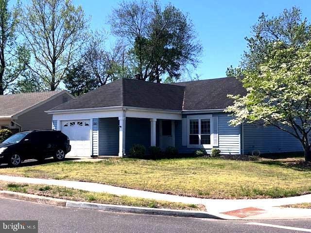 single story home with an attached garage and a front lawn