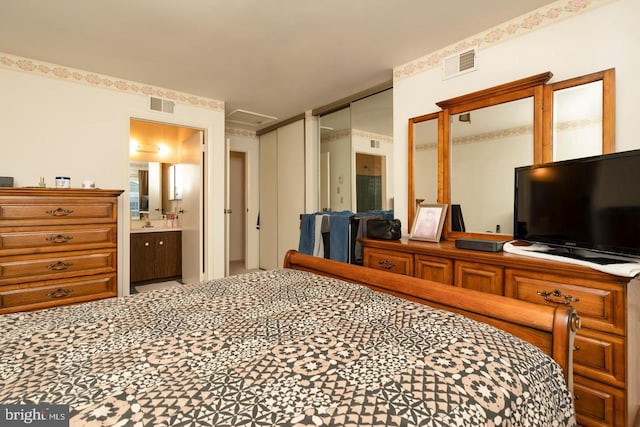 bedroom with connected bathroom and visible vents