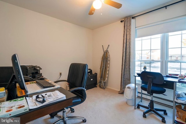carpeted office with baseboards, a ceiling fan, a baseboard radiator, and a healthy amount of sunlight