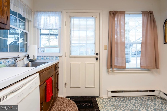 doorway with plenty of natural light, a sink, a baseboard heating unit, and tile patterned floors