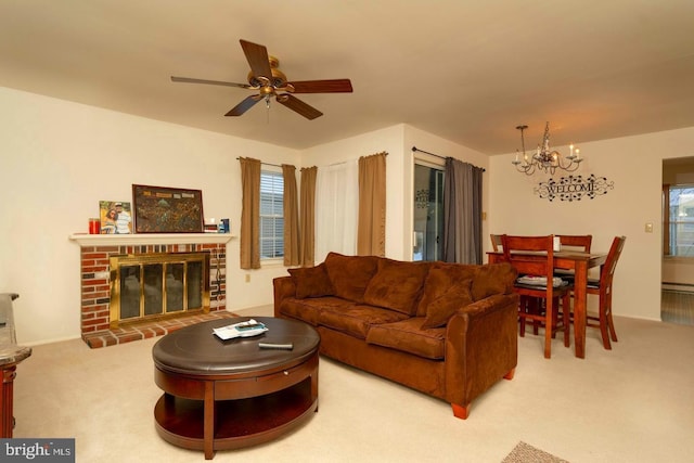 living area featuring a fireplace, light carpet, and ceiling fan with notable chandelier