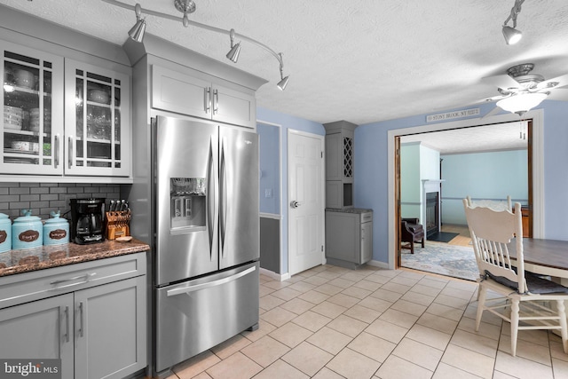 kitchen with stainless steel fridge, rail lighting, gray cabinets, and a textured ceiling