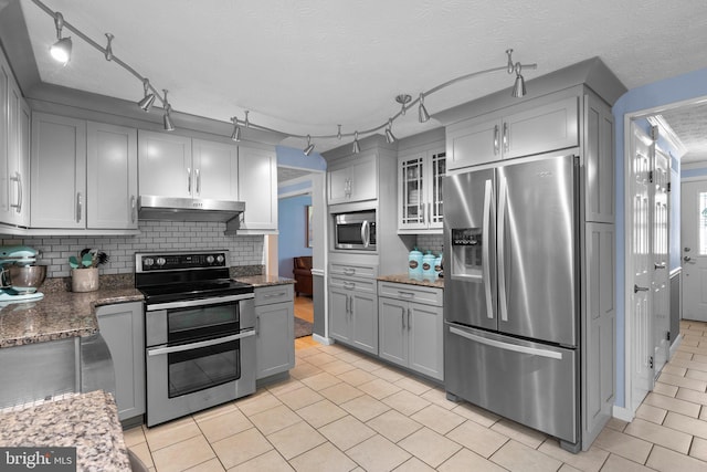 kitchen featuring appliances with stainless steel finishes, under cabinet range hood, gray cabinets, light tile patterned floors, and a textured ceiling