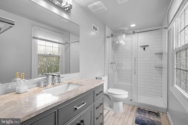 full bath featuring a stall shower, toilet, and vanity