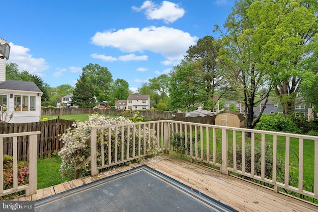 deck featuring a storage shed, an outbuilding, and a residential view