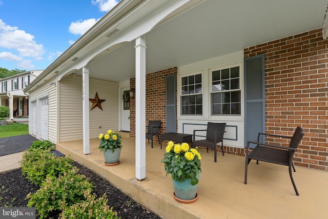 view of patio / terrace featuring covered porch and an attached garage