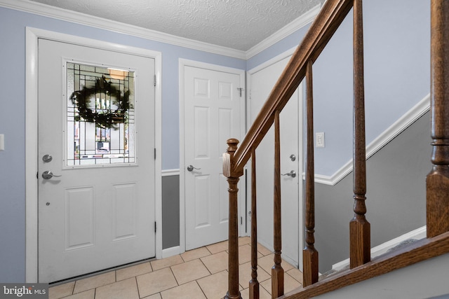 foyer featuring stairs, a textured ceiling, light tile patterned floors, ornamental molding, and baseboards