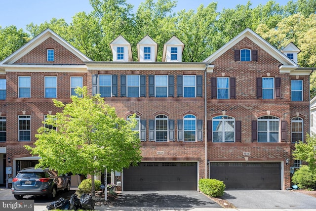 multi unit property featuring brick siding, an attached garage, and driveway