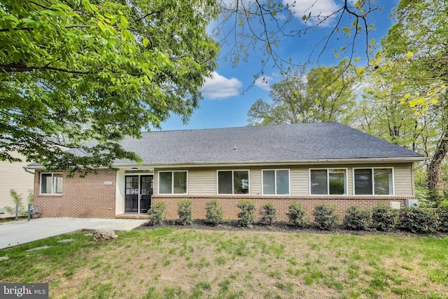view of front of house with a patio area, a front lawn, and brick siding