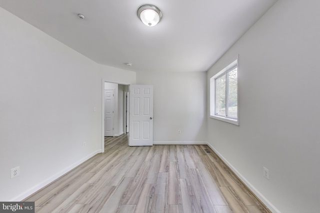 unfurnished room featuring light wood-style floors and baseboards