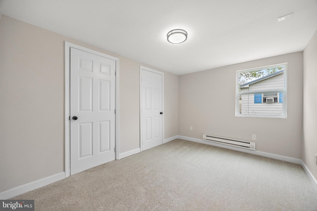 unfurnished bedroom with baseboard heating, baseboards, cooling unit, and carpet