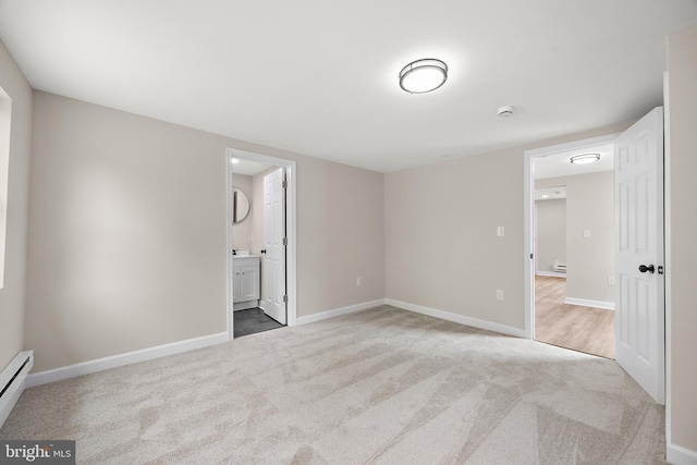 unfurnished bedroom with a baseboard radiator, baseboards, and carpet flooring