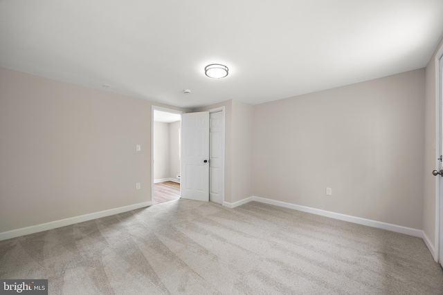spare room with baseboards and carpet flooring