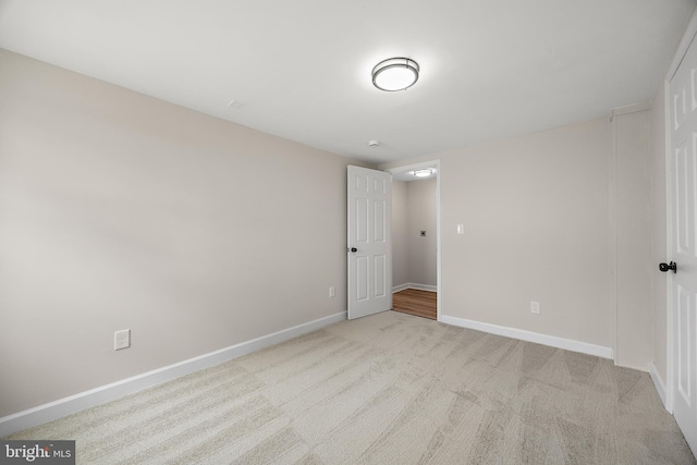 unfurnished bedroom with light colored carpet and baseboards