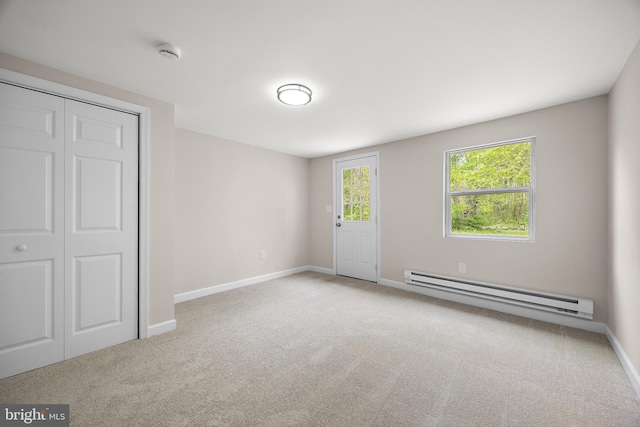 unfurnished bedroom with a baseboard radiator, carpet floors, a closet, and baseboards