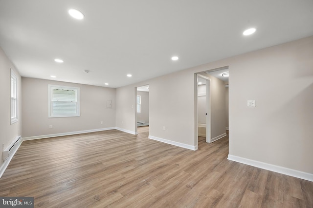 interior space with a baseboard heating unit, light wood-type flooring, and recessed lighting