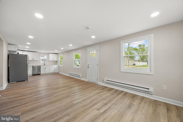 unfurnished living room with recessed lighting, light wood-style floors, and a baseboard radiator