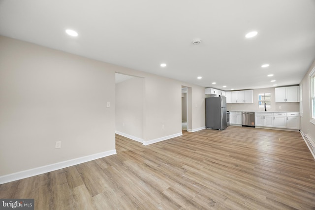 unfurnished living room with baseboards, light wood-style flooring, and recessed lighting