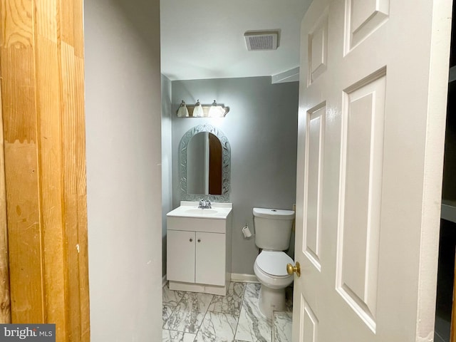 bathroom with vanity, marble finish floor, baseboards, toilet, and visible vents