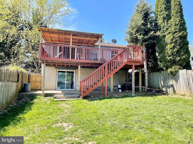 rear view of house with central AC, a deck, a fenced backyard, a yard, and stairs