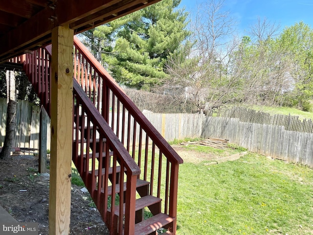 deck featuring a lawn, a fenced backyard, and stairs