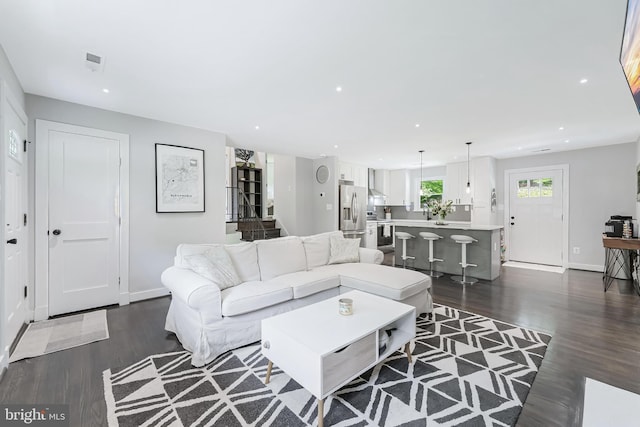 living room with dark wood-type flooring, baseboards, and recessed lighting